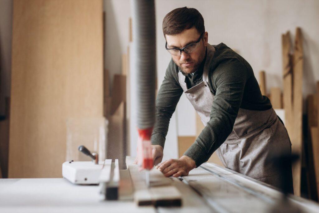 Schreiner, der mit Holz und Säge in der verarbeitenden Industrie arbeitet