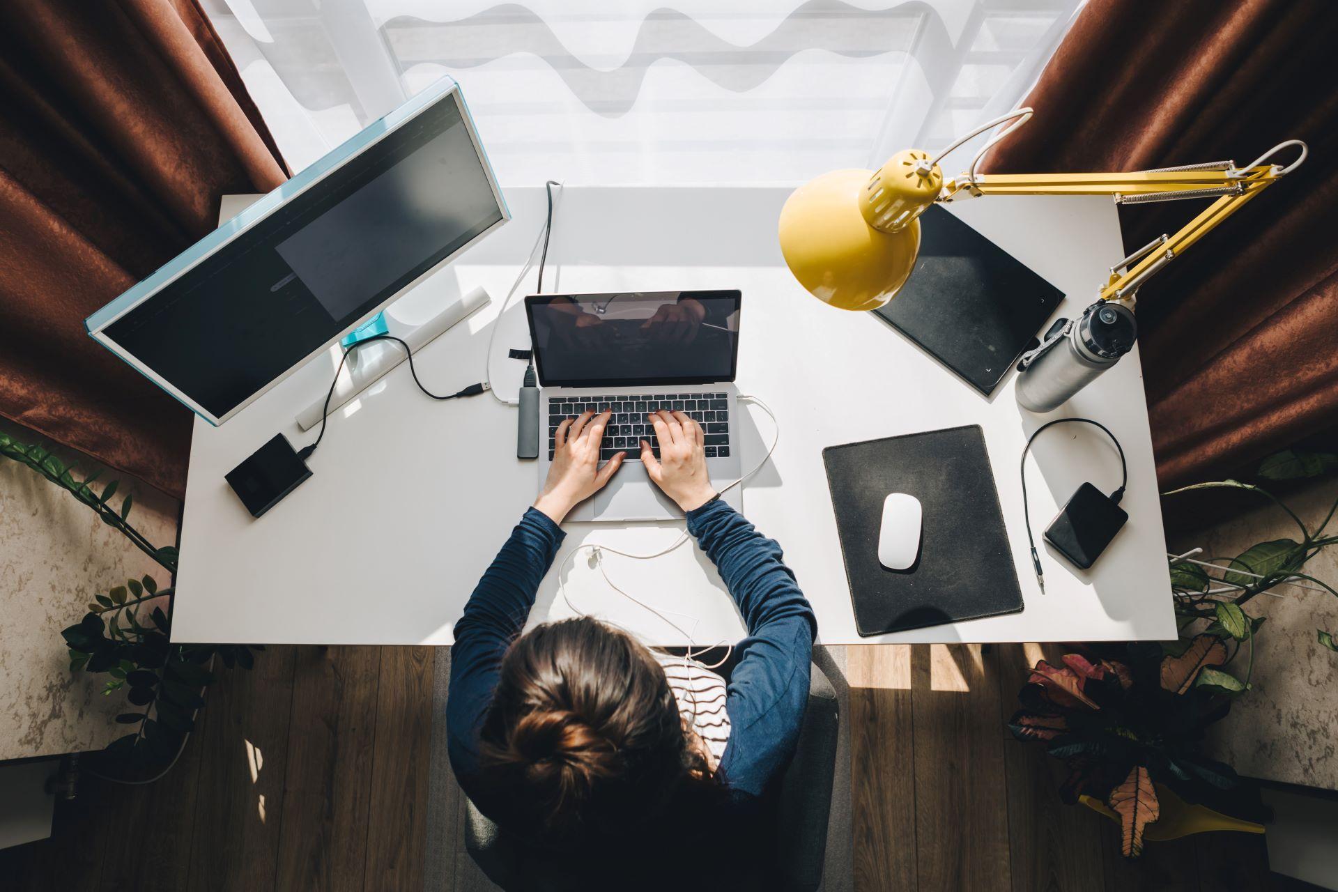 Laptop und Monitor auf einem modernen Homeoffice-Arbeitsplatz.